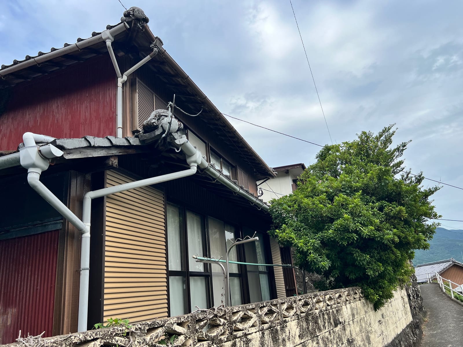 雨戸を閉めたまま空き家になっている、瓦屋根の日本家屋